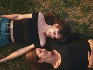 young and older woman lying in grass