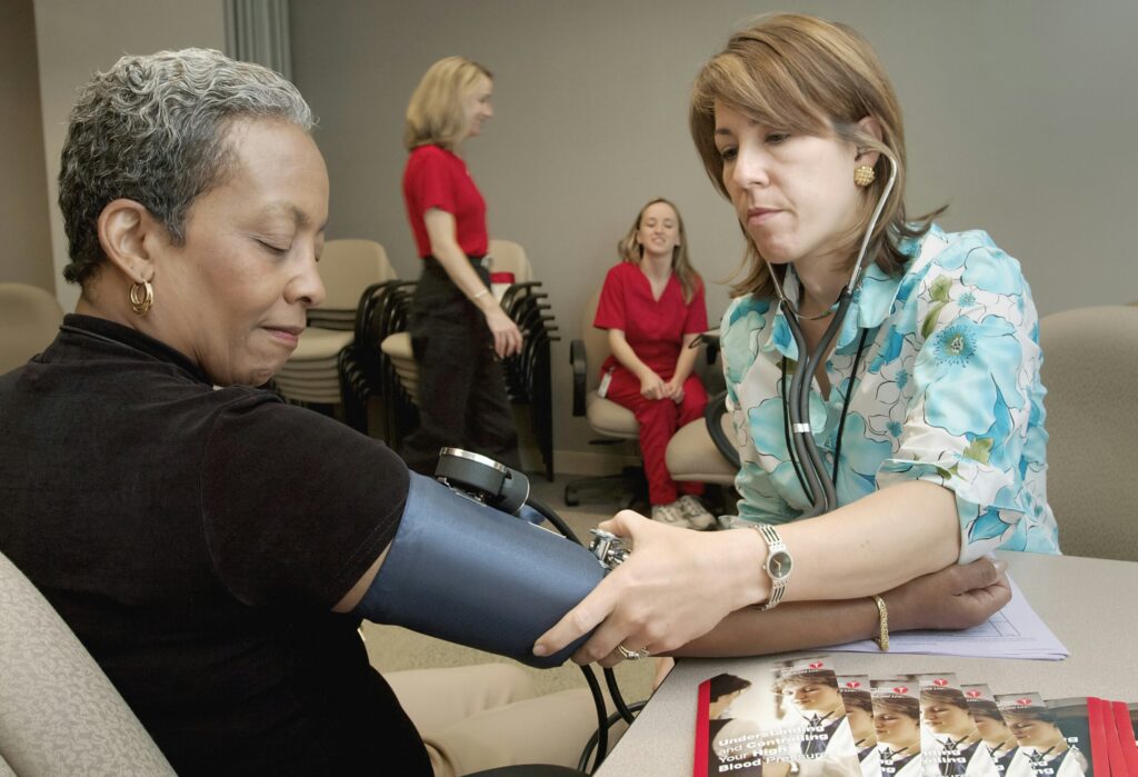 health care provider taking black woman's blood pressure